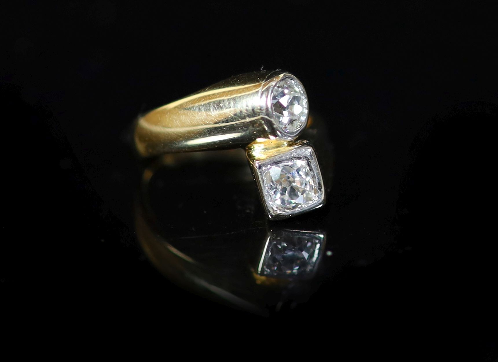 A Continental gold and collet set two stone diamond crossover ring
